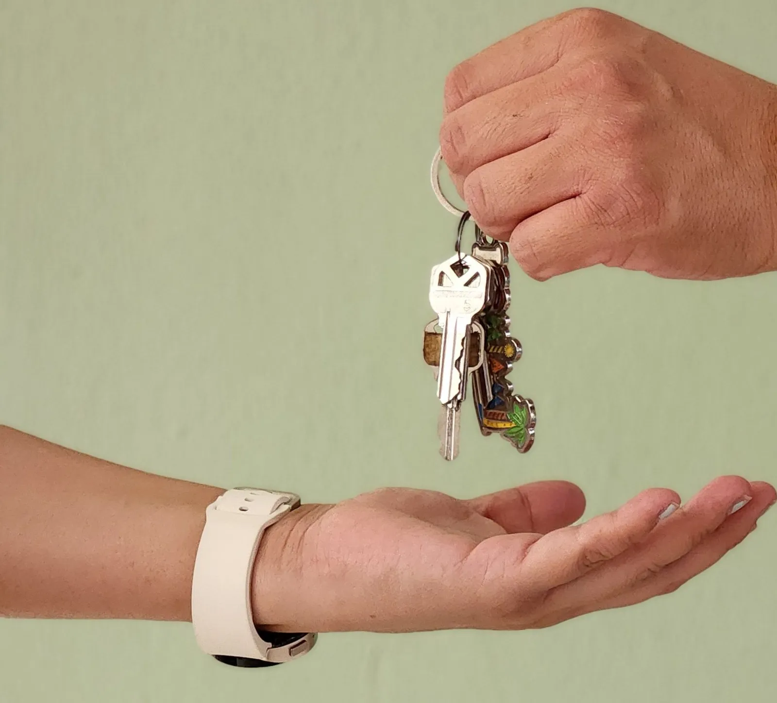 One hand passes a set of keys to another open hand