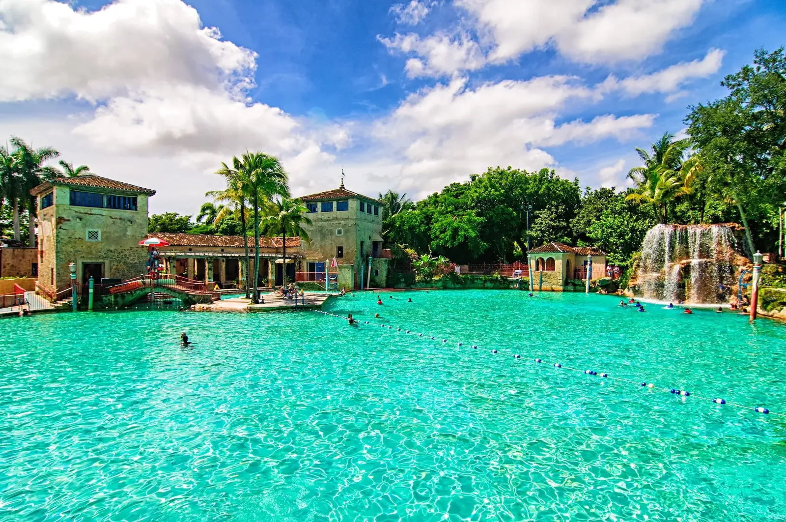 Coral Gables' Venetian Pool, a large turquoise pool surrounded by stone towers, palm trees and a waterfall