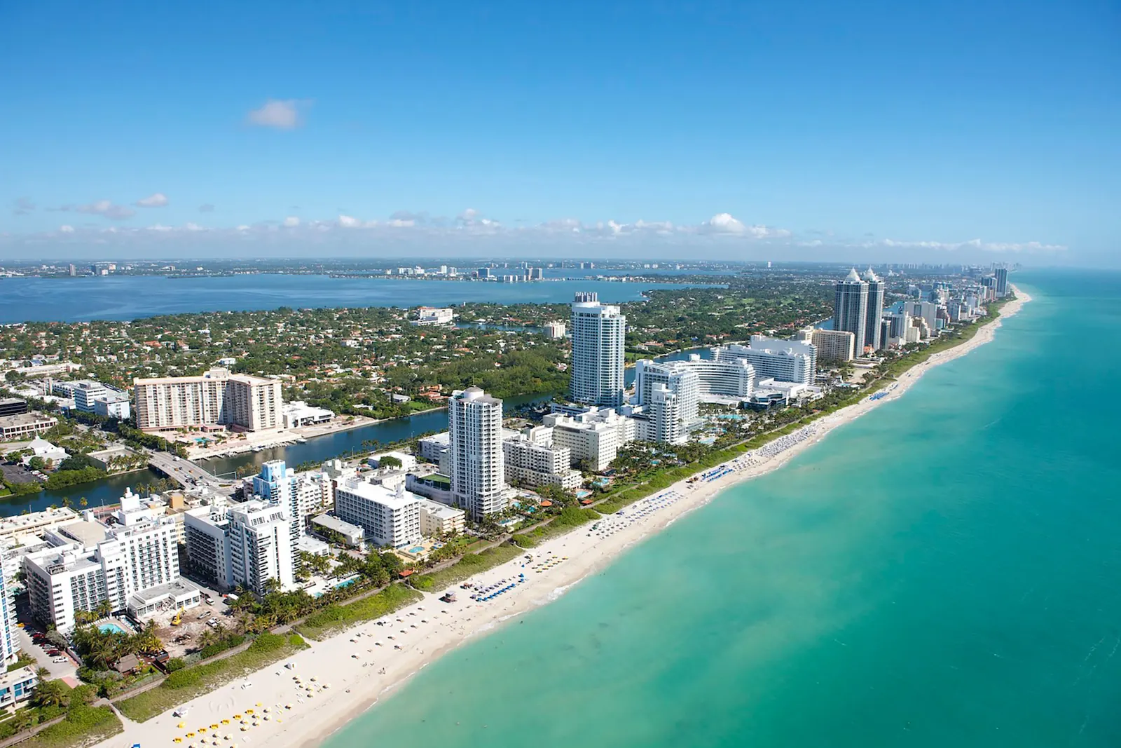Aerial view of Miami Beach, with oceanfront towers, the beach and Biscayne Bay in the background