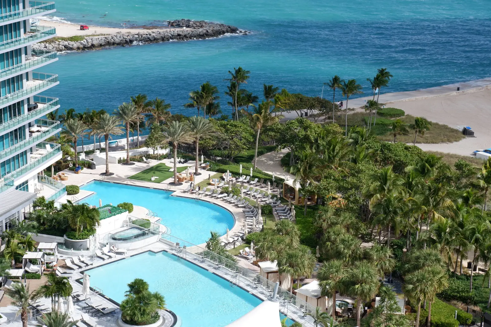 Pools, palm-lined gardens and beach at a luxury oceanfront residential complex in Miami